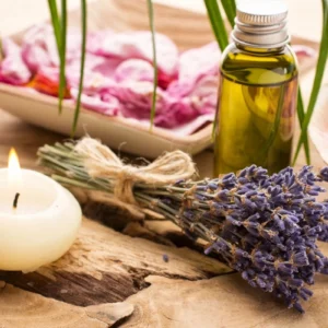 Aromatherapy setup with lavender, candle, and essential oil bottle.