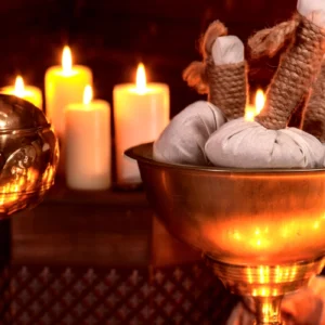 Spa setting with herbal compresses and candles creating a relaxing atmosphere.