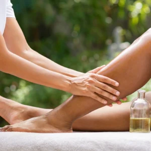 Person receiving a relaxing leg massage outdoors.