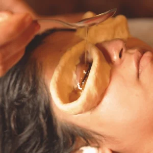 Person receiving a golden eye mask treatment for skin care.
