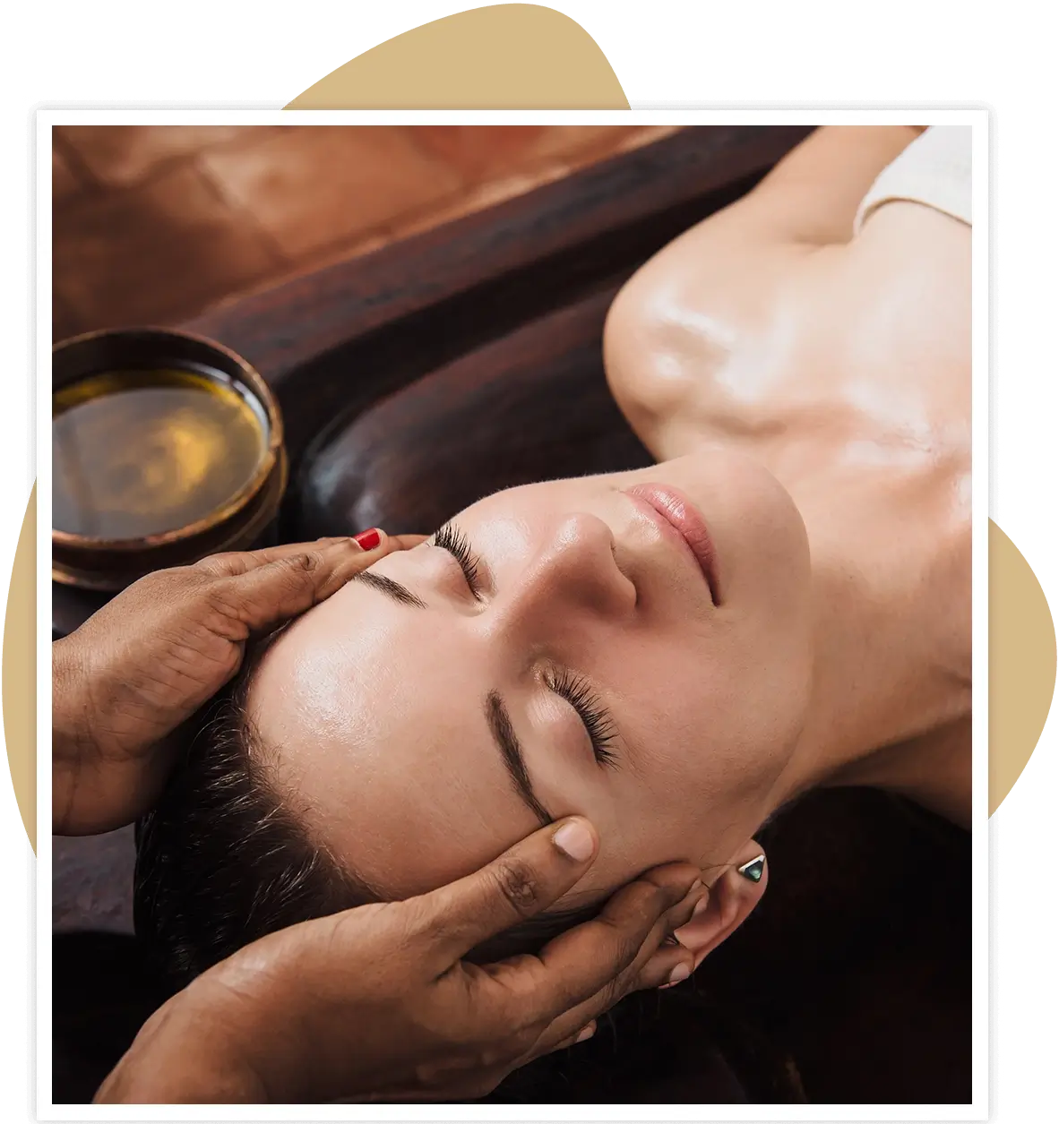 Person receiving a relaxing facial massage with warm oil.