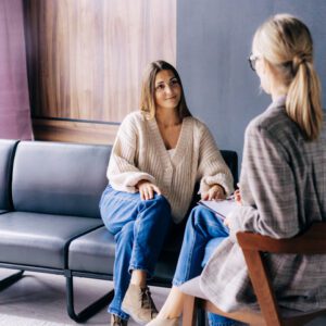 Two women engaged in a thoughtful conversation in a cozy room.