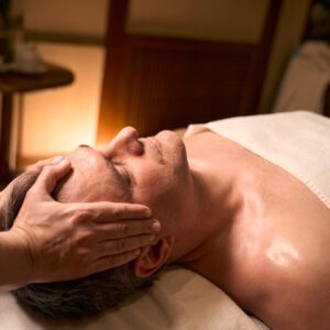 Person receiving a relaxing facial massage in a spa setting.