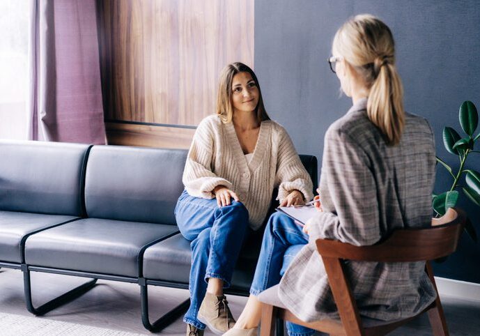 Two women engaged in a thoughtful conversation in a cozy room.