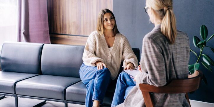 Two women engaged in a thoughtful conversation in a cozy room.