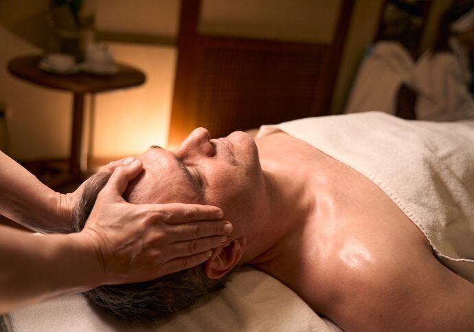 Person receiving a relaxing facial massage in a spa setting.