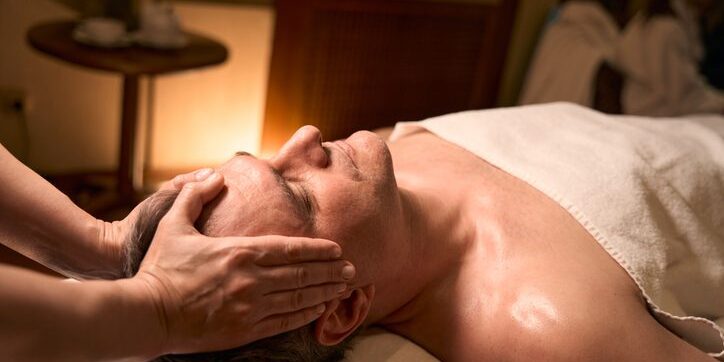 Person receiving a relaxing facial massage in a spa setting.